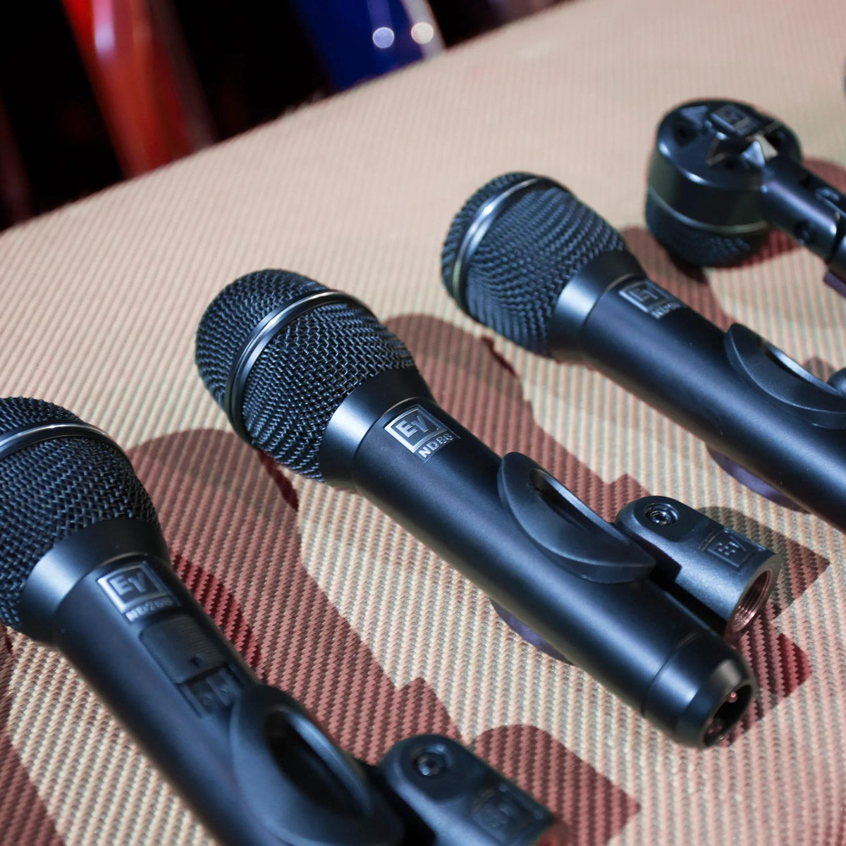 Electro-Voice ND Series microphones laid out on a tweed amp case